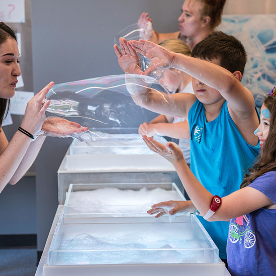 children playing with a bubble table